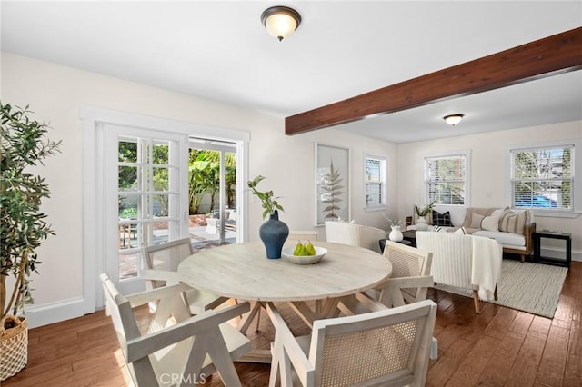 dining room with dark wood-style floors, a wealth of natural light, and beamed ceiling