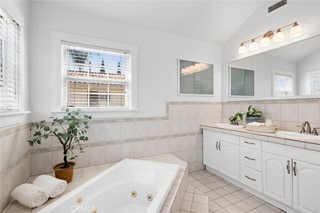 bathroom featuring vaulted ceiling, visible vents, a sink, and double vanity