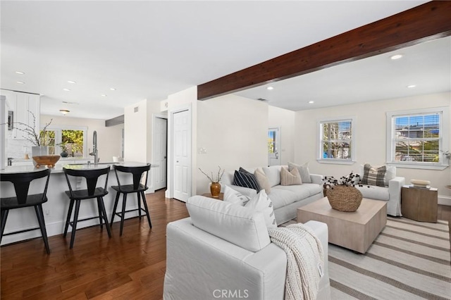 living area with recessed lighting, beam ceiling, and wood finished floors