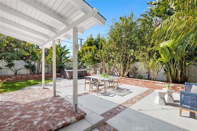 view of patio with outdoor dining space, a fenced backyard, and a hot tub