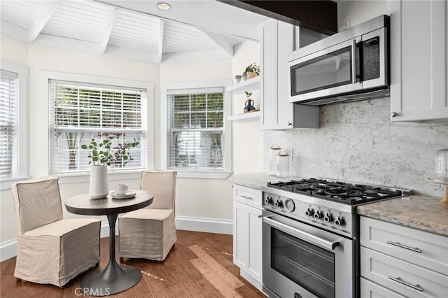 kitchen featuring stainless steel appliances, light stone counters, open shelves, and white cabinetry