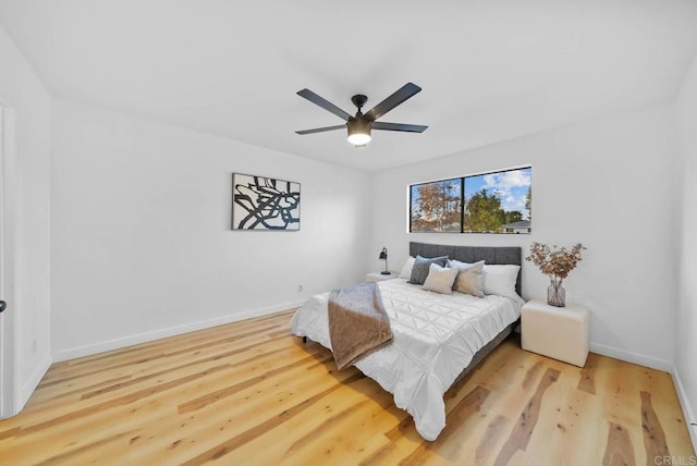 bedroom featuring a ceiling fan, baseboards, and wood finished floors