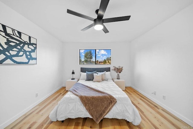 bedroom featuring ceiling fan, baseboards, and wood finished floors