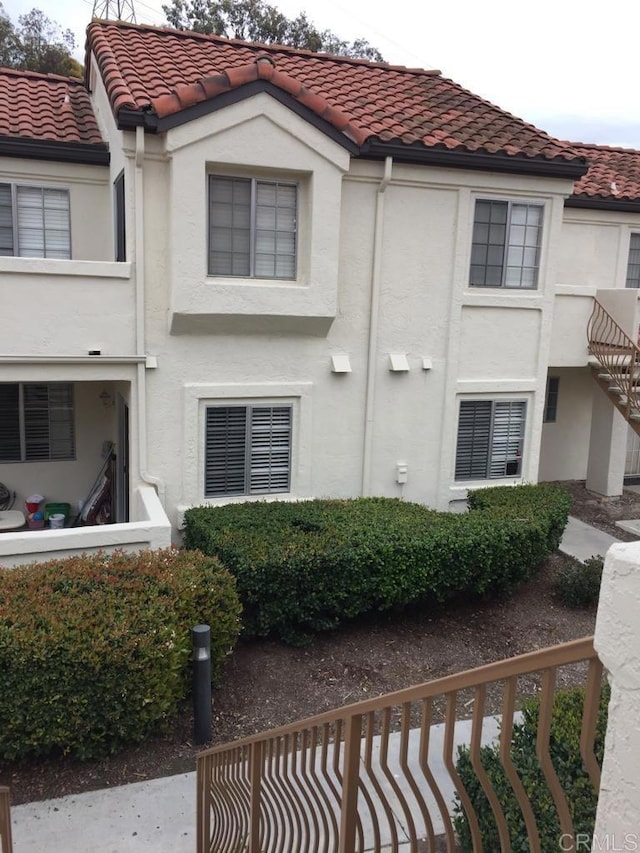 view of front of house with a tile roof and stucco siding