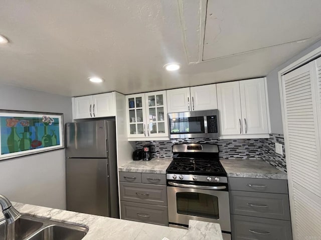 750 Eastshore Ter Unit 120, Chula Vista, CA 91913 - kitchen featuring stainless steel appliances, gray cabinets, glass insert cabinets, a sink, and recessed lighting
