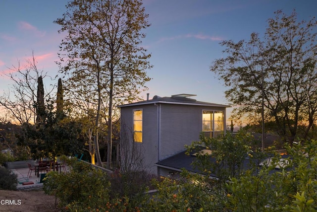 property exterior at dusk with a patio area