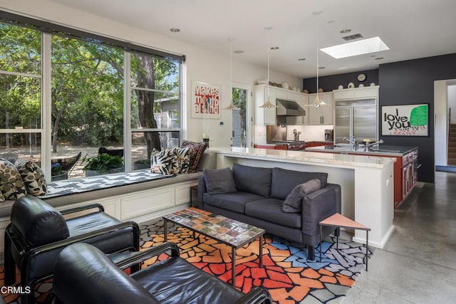 living room featuring a skylight, visible vents, and concrete floors