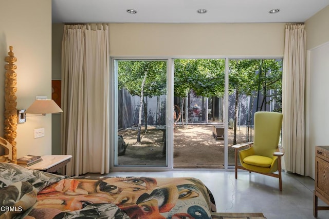 bedroom featuring access to exterior, multiple windows, and finished concrete flooring