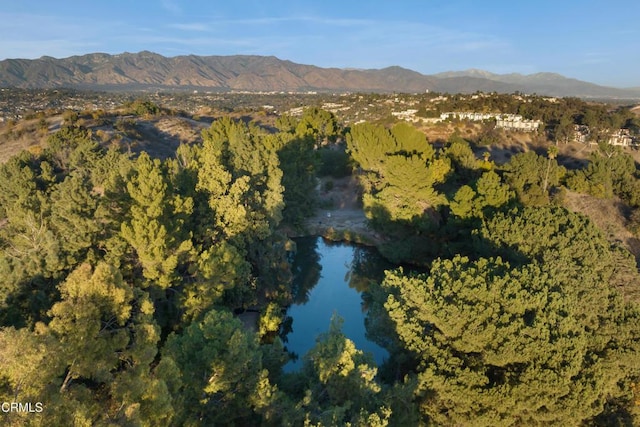 bird's eye view featuring a wooded view and a water and mountain view