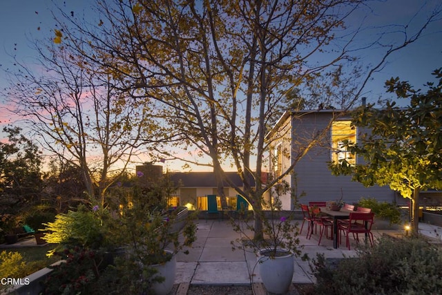 back of property at dusk with a patio area