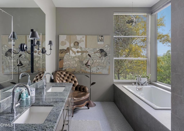 bathroom featuring double vanity, a relaxing tiled tub, a sink, and tile patterned flooring