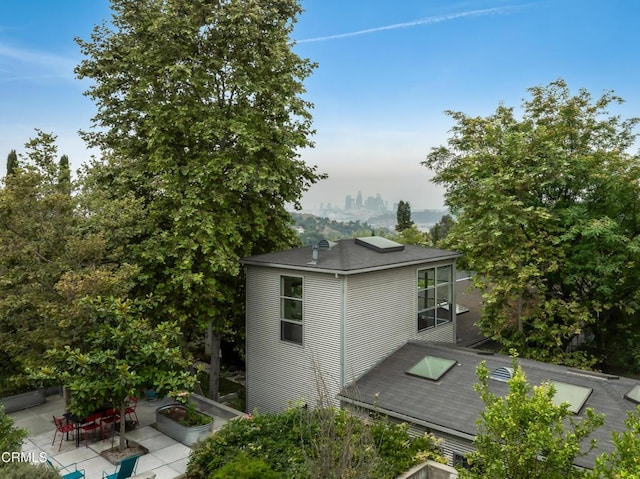 view of side of property featuring a patio area and a city view