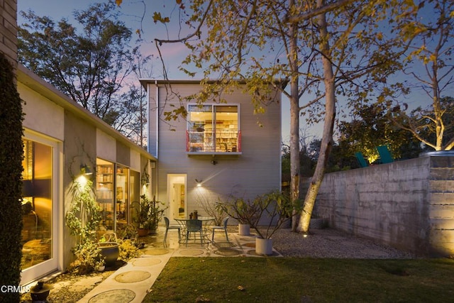 rear view of property featuring fence and a patio