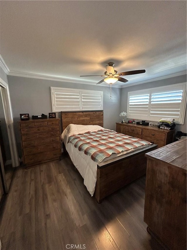 bedroom featuring ornamental molding, dark wood-type flooring, and a ceiling fan