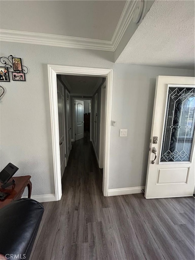 hall featuring dark wood-style floors, crown molding, a textured ceiling, and baseboards