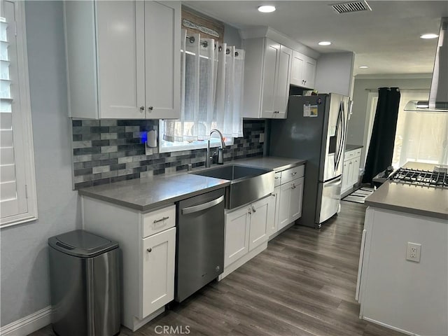 kitchen featuring white cabinets, visible vents, stainless steel appliances, and a sink