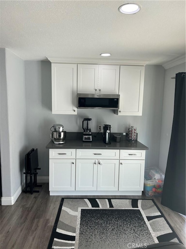 bar featuring recessed lighting, baseboards, dark wood finished floors, a textured ceiling, and exhaust hood