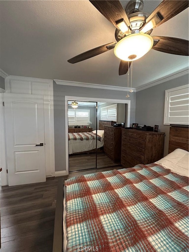 unfurnished bedroom with a closet, a ceiling fan, dark wood-type flooring, and crown molding