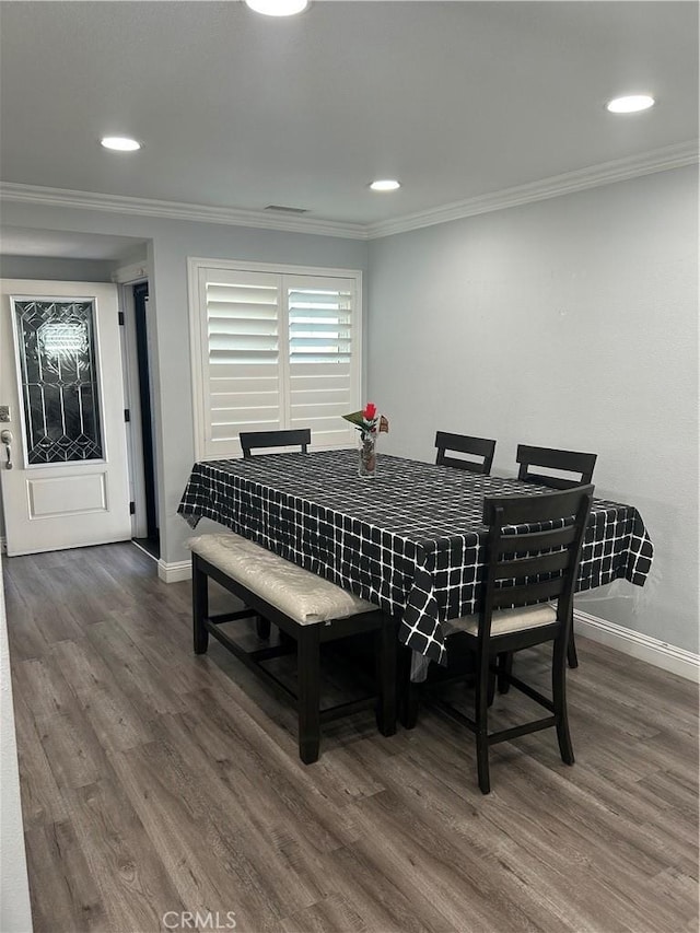 dining space featuring baseboards, dark wood finished floors, crown molding, and recessed lighting