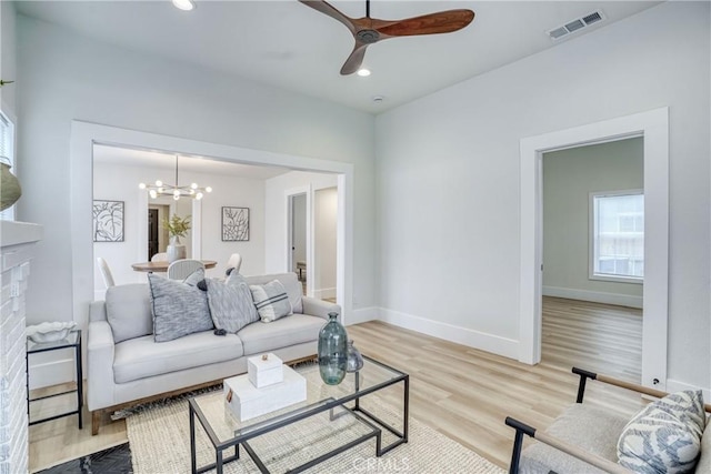 living area with recessed lighting, visible vents, baseboards, light wood-style flooring, and ceiling fan with notable chandelier