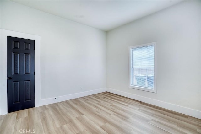 empty room with light wood-type flooring and baseboards