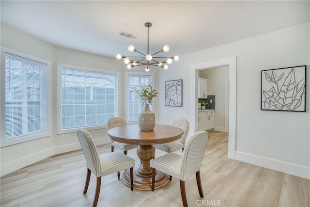 dining room featuring visible vents, light wood-style flooring, baseboards, and an inviting chandelier