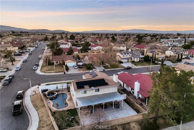 aerial view at dusk featuring a residential view and a mountain view