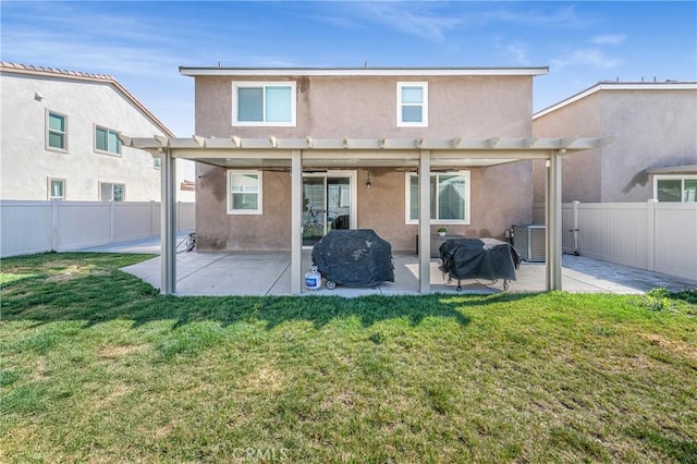 rear view of house featuring a patio area, a yard, a fenced backyard, and stucco siding