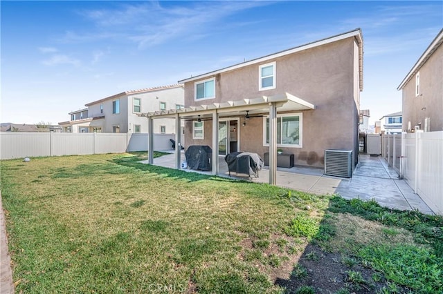 rear view of house featuring a yard, a patio area, a fenced backyard, and stucco siding