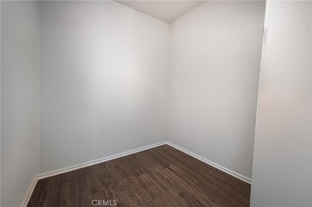 empty room with baseboards and wood finished floors