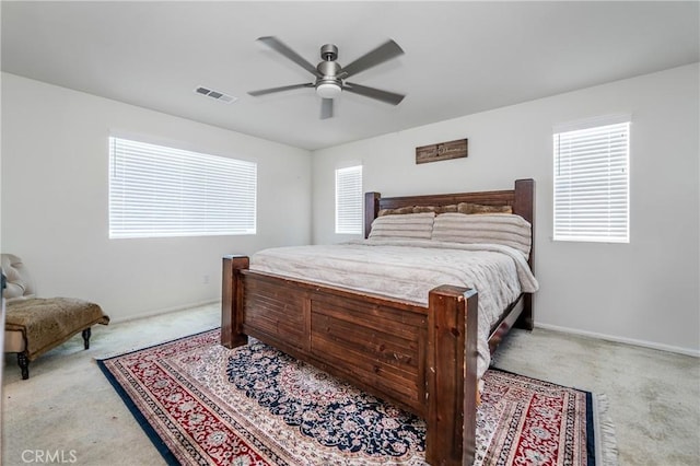 bedroom featuring light carpet, baseboards, visible vents, and a ceiling fan