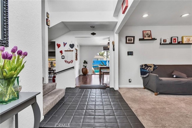 interior space featuring baseboards, stairway, dark carpet, and recessed lighting