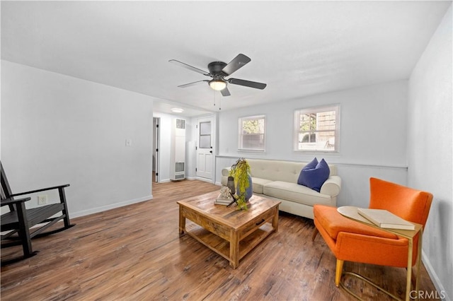 living area with wood finished floors, a ceiling fan, and baseboards