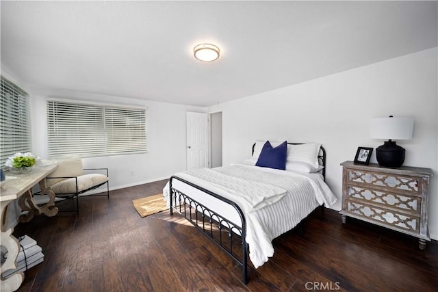 bedroom with dark wood-type flooring and baseboards