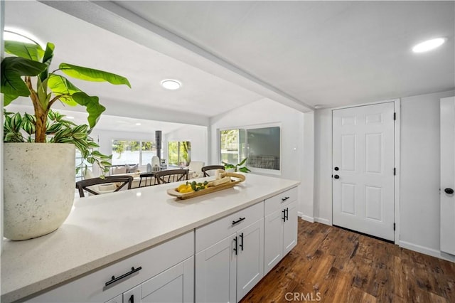 kitchen featuring dark wood-style floors, white cabinets, light countertops, and baseboards