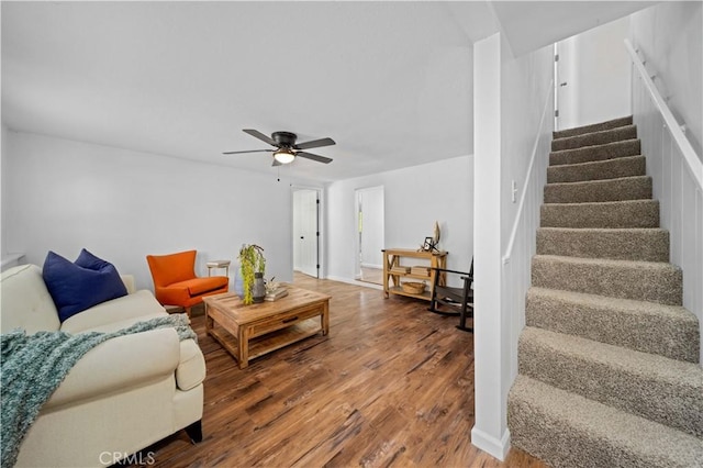 living room with a ceiling fan, stairway, and wood finished floors