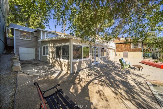 rear view of property with a patio and a fire pit