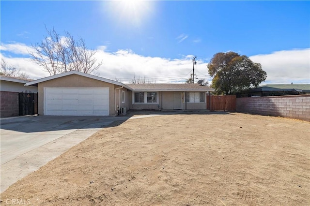 single story home featuring a garage, driveway, fence, and stucco siding