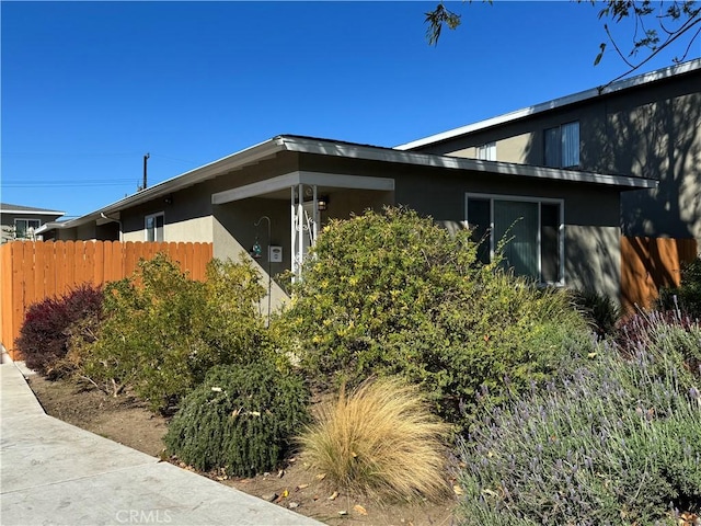 view of property exterior with fence and stucco siding