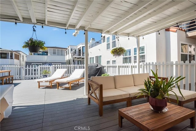 wooden terrace with an outdoor living space and area for grilling