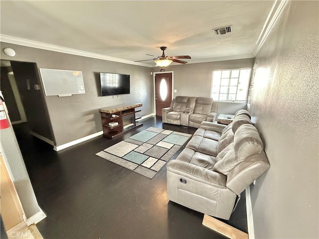 living area featuring dark wood-style flooring, crown molding, visible vents, a ceiling fan, and baseboards