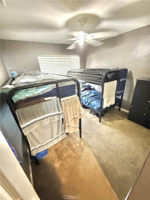 bedroom with a ceiling fan, carpet, a textured ceiling, and baseboards