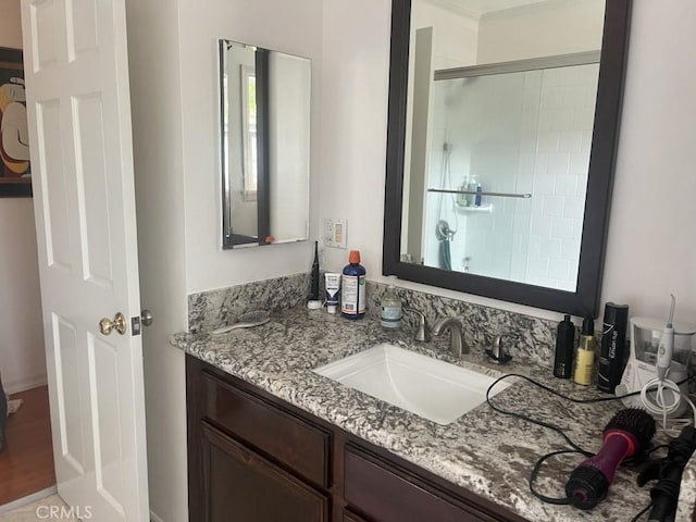 bathroom with a shower stall and vanity