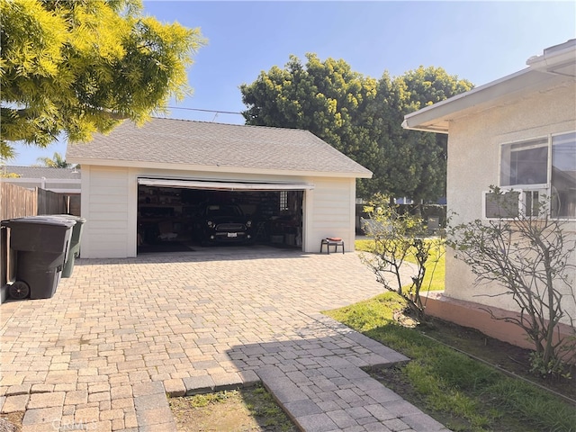 detached garage featuring fence