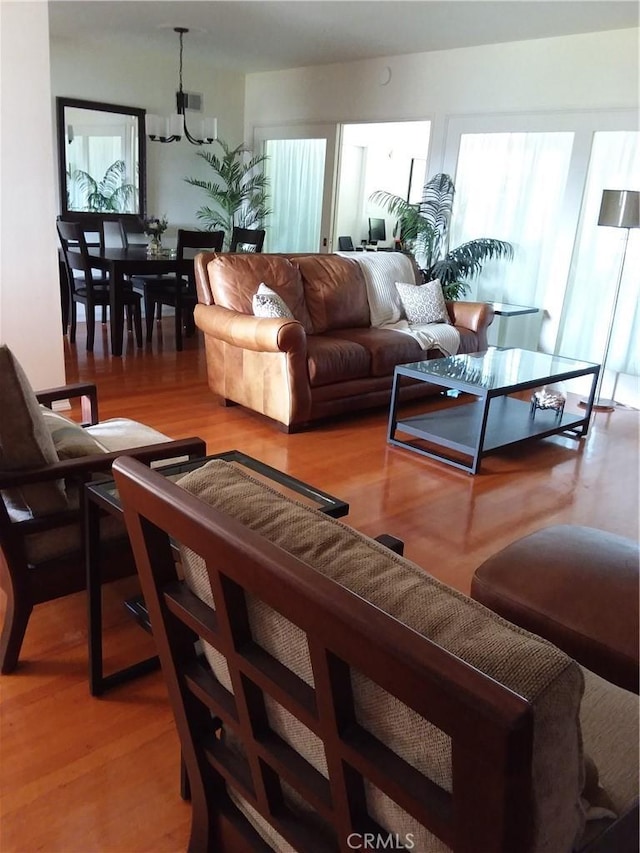 living room with a notable chandelier and wood finished floors