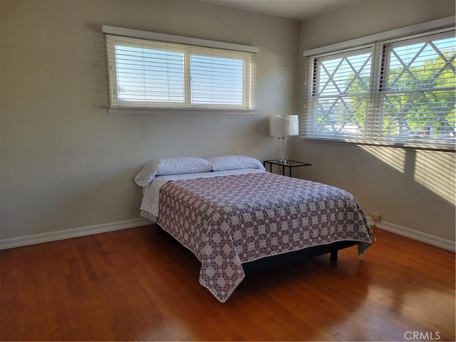 bedroom featuring baseboards and wood finished floors