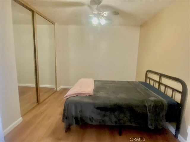 bedroom featuring ceiling fan, baseboards, and wood finished floors