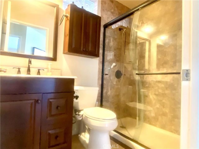 full bath with a stall shower, vanity, and toilet