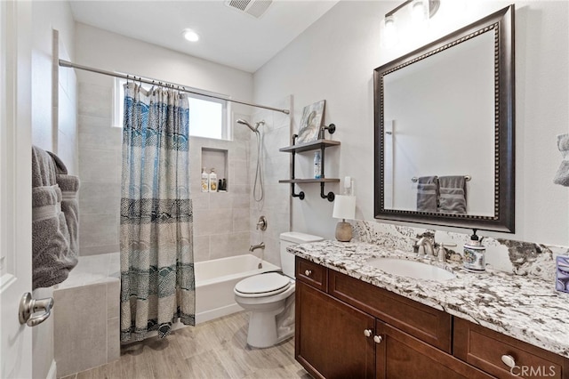 full bathroom with visible vents, toilet, wood finished floors, shower / bath combo with shower curtain, and vanity