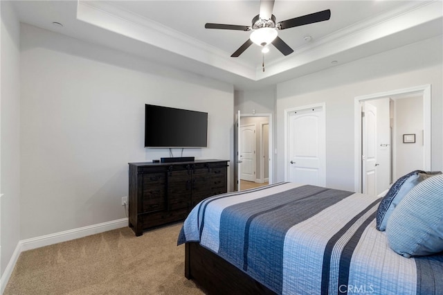 bedroom with baseboards, ornamental molding, a raised ceiling, and light colored carpet